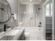 Well-lit bathroom features a shower-tub combo with gray marbled tile and updated fixtures at 301 Riverwood Rd, Mooresville, NC 28117