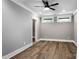 Spacious bedroom with hardwood floors, modern fan, and two windows allowing for natural light at 301 Riverwood Rd, Mooresville, NC 28117