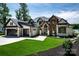 Gorgeous modern home with a manicured lawn, stunning stone and wood accents, and a spacious driveway at 301 Riverwood Rd, Mooresville, NC 28117