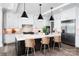 Bright kitchen with stainless steel appliances, marble countertops, and stylish wooden chairs at the island at 301 Riverwood Rd, Mooresville, NC 28117