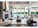 Open living room with stone fireplace, large windows, and stunning lake views at 301 Riverwood Rd, Mooresville, NC 28117