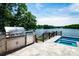 Built-in outdoor stainless steel grill and bar area with stunning lake views at 301 Riverwood Rd, Mooresville, NC 28117