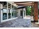 Covered outdoor patio with travertine tile, wood beams and stone pillars at 301 Riverwood Rd, Mooresville, NC 28117