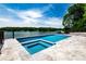 Stunning pool and hot tub overlooking the lake with a travertine surround and gorgeous views at 301 Riverwood Rd, Mooresville, NC 28117