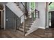 Stylish staircase featuring wood steps, modern cable railings, and contrasting wall paneling for a contemporary aesthetic at 301 Riverwood Rd, Mooresville, NC 28117