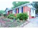 A cozy home displaying landscaped garden beds and a well-kept exterior and a paved driveway at 3016 Boston Ave, Charlotte, NC 28212