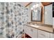 Bathroom with granite countertop, floral shower curtain, and wood-framed mirror at 3988 Old Hickory Rd, Lancaster, SC 29720