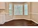 Bright dining area features a bay window, hardwood flooring, and white cabinets at 4504 Bellmore Ct, Charlotte, NC 28269