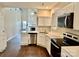 Bright kitchen boasts white cabinets, modern stainless steel appliances, and views of the great room at 4504 Bellmore Ct, Charlotte, NC 28269