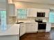 Bright kitchen featuring white cabinets, light countertops, and stainless steel appliances at 4504 Bellmore Ct, Charlotte, NC 28269
