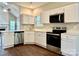 Bright kitchen features white cabinets, modern stainless steel appliances and light countertops at 4504 Bellmore Ct, Charlotte, NC 28269