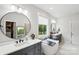 Light-filled bathroom with dual vanities, a soaking tub, and a view of the outdoors at 4530 Tournette Dr # 18, Indian Land, SC 29707