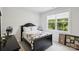 Cozy bedroom with a dark-colored bed frame, neutral walls, and a window offering a view of the lush greenery outside at 4530 Tournette Dr # 18, Indian Land, SC 29707