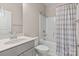Well-lit bathroom featuring a tub with shower, neutral wall paint, and tiled walls at 4975 Looking Glass Trl, Denver, NC 28037
