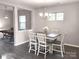 A dining room features a wooden table with white chairs and a chandelier hanging above at 4975 Looking Glass Trl, Denver, NC 28037
