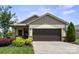 Charming home featuring a two-car garage, neutral siding, and beautifully landscaped front yard with colorful plants at 4975 Looking Glass Trl, Denver, NC 28037
