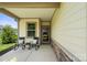 Inviting front porch with rocking chairs, decorative pillows, and a flower pot, creating a welcoming entrance at 4975 Looking Glass Trl, Denver, NC 28037