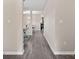 Hallway showcasing durable gray laminate flooring, neutral paint, and open sightlines to living spaces at 4975 Looking Glass Trl, Denver, NC 28037