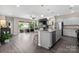 Open-concept kitchen flowing into the living room with stainless steel appliances and center island seating at 4975 Looking Glass Trl, Denver, NC 28037