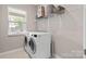 Laundry room featuring a white washer and dryer with a shelf and window at 4975 Looking Glass Trl, Denver, NC 28037