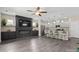 Open-concept living room with modern fireplace and shelving flowing into the kitchen with barstool seating at 4975 Looking Glass Trl, Denver, NC 28037