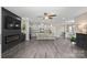 Open-concept living space features an island with seating and modern fireplace with grey laminate floors at 4975 Looking Glass Trl, Denver, NC 28037