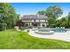 Spacious backyard with a pool, hot tub, manicured lawn, mature trees, and patio area for entertaining at 5523 Meadow Haven Ln, Charlotte, NC 28270