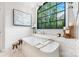 Bright bathroom with a modern standalone tub with a large picture window and geometric tile accents at 5523 Meadow Haven Ln, Charlotte, NC 28270