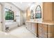Bright bathroom featuring a modern tub under a picture window, chandelier, double vanity, and glass enclosed shower at 5523 Meadow Haven Ln, Charlotte, NC 28270