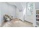 Comfortable bedroom with a floral chair, built-in shelving, and a large window at 5523 Meadow Haven Ln, Charlotte, NC 28270