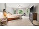Bright bedroom featuring a large bed, ceiling fan, TV, seating area with lots of natural light from multiple windows at 5523 Meadow Haven Ln, Charlotte, NC 28270
