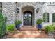 Elegant stone entryway with double doors framed by beautiful landscaping and decorative wreaths at 5523 Meadow Haven Ln, Charlotte, NC 28270