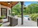 Covered outdoor patio featuring stone floors, comfortable seating, and a view of the pool and backyard at 5523 Meadow Haven Ln, Charlotte, NC 28270