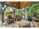 Cozy sunroom with comfortable seating, a wood plank ceiling, and views of the yard at 5523 Meadow Haven Ln, Charlotte, NC 28270