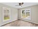 Bedroom with wood-look flooring, two windows, and a modern ceiling fan at 626 W Bell St, Statesville, NC 28677