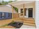 Inviting front porch with wooden railings and a stylish black door, enhancing the home's curb appeal at 626 W Bell St, Statesville, NC 28677