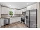 Modern kitchen with granite countertops, stainless steel appliances, and white cabinets at 626 W Bell St, Statesville, NC 28677