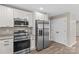 Kitchen boasts stainless steel appliances, granite countertops, and white cabinets for a modern feel at 626 W Bell St, Statesville, NC 28677