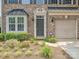 Brick townhome with charming landscaping, featuring a one-car garage and a welcoming front entrance at 6505 Central Pacific Ave, Charlotte, NC 28210