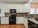 Bright kitchen featuring white cabinets, granite countertops, and black appliances at 6505 Central Pacific Ave, Charlotte, NC 28210
