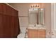 Well-lit bathroom with a vanity, toilet, and a shower with decorative curtain at 7007 Broad Leaf Ct, Indian Trail, NC 28079