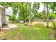Backyard boasts a grassy lawn, mature trees, wood fence, and storage shed at 7442 Crestside Ln, Charlotte, NC 28227