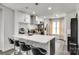 Modern kitchen featuring stainless steel appliances, a breakfast bar with seating, and stylish pendant lighting at 7442 Crestside Ln, Charlotte, NC 28227