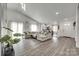 Spacious living room with hardwood floors and natural lighting, seamlessly connecting to the kitchen area at 7442 Crestside Ln, Charlotte, NC 28227