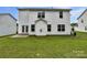 Spacious backyard with a well-maintained lawn and the home's exterior featuring white siding at 752 Raindrops Rd, Gastonia, NC 28054