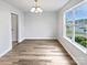 Well-lit dining room featuring wood floors, a modern light fixture, and a large window with neighborhood views at 752 Raindrops Rd, Gastonia, NC 28054