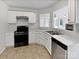 Well-lit kitchen featuring white cabinets, stainless steel appliances, and a seamless view into the living space at 752 Raindrops Rd, Gastonia, NC 28054