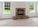 Inviting living room with a stone fireplace, flanked by windows with verdant outdoor views at 752 Raindrops Rd, Gastonia, NC 28054