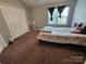 Cozy bedroom showcasing a neutral color palette, plush carpeting, and a large window providing natural light at 7562 Petrea Ln, Charlotte, NC 28227