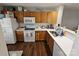 Functional kitchen featuring wooden cabinets, white appliances, and a seamless countertop for efficient meal preparation at 7562 Petrea Ln, Charlotte, NC 28227